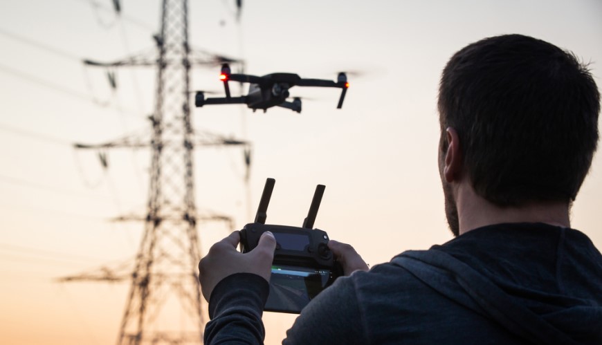 Ako vybrať dron? Muž ovláda dron pomocou diaľkového ovládača