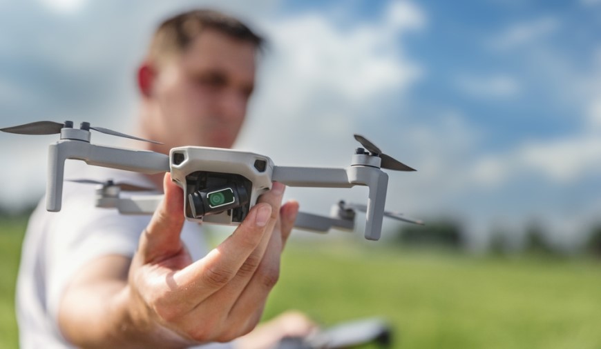 Ako vybrať dron? Muž drží v ruke dron