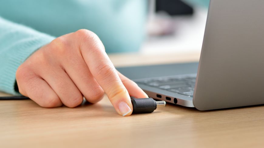 Čo robiť, keď si polejete notebook? Žena odpája notebook od napájania