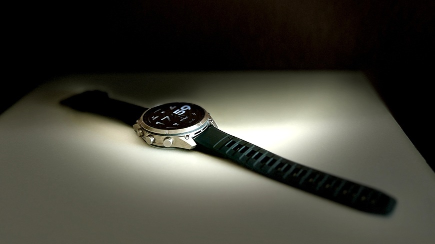 Inteligentné hodinky Garmin fēnix® 9 Pro v detaile s krabičkou na slabo osvetlenej poličke