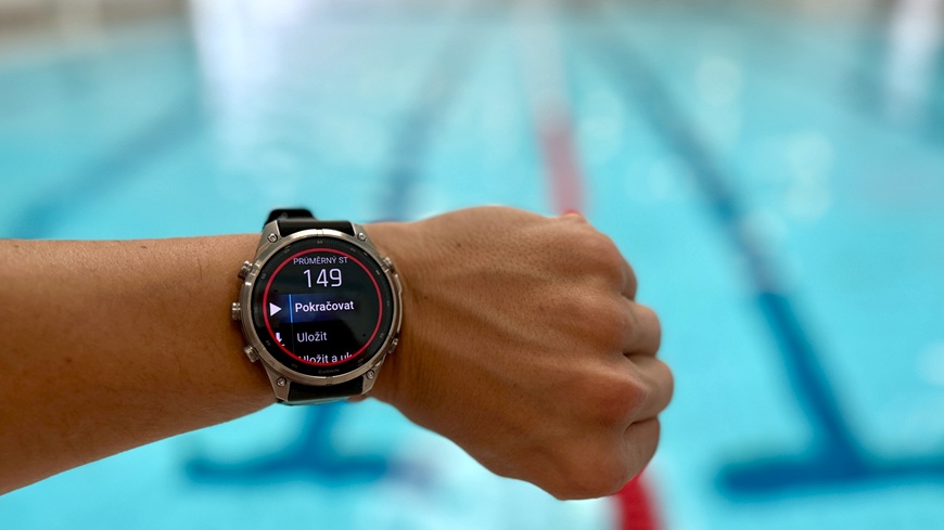 Inteligentné hodinky Garmin fēnix® 9 Pro v detaile na zápästí v popredí plaveckého bazéna