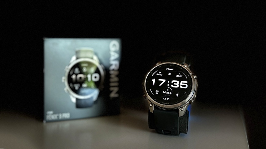 Inteligentné hodinky Garmin fēnix® 9 Pro v detaile s krabičkou na slabo osvetlenej poličke