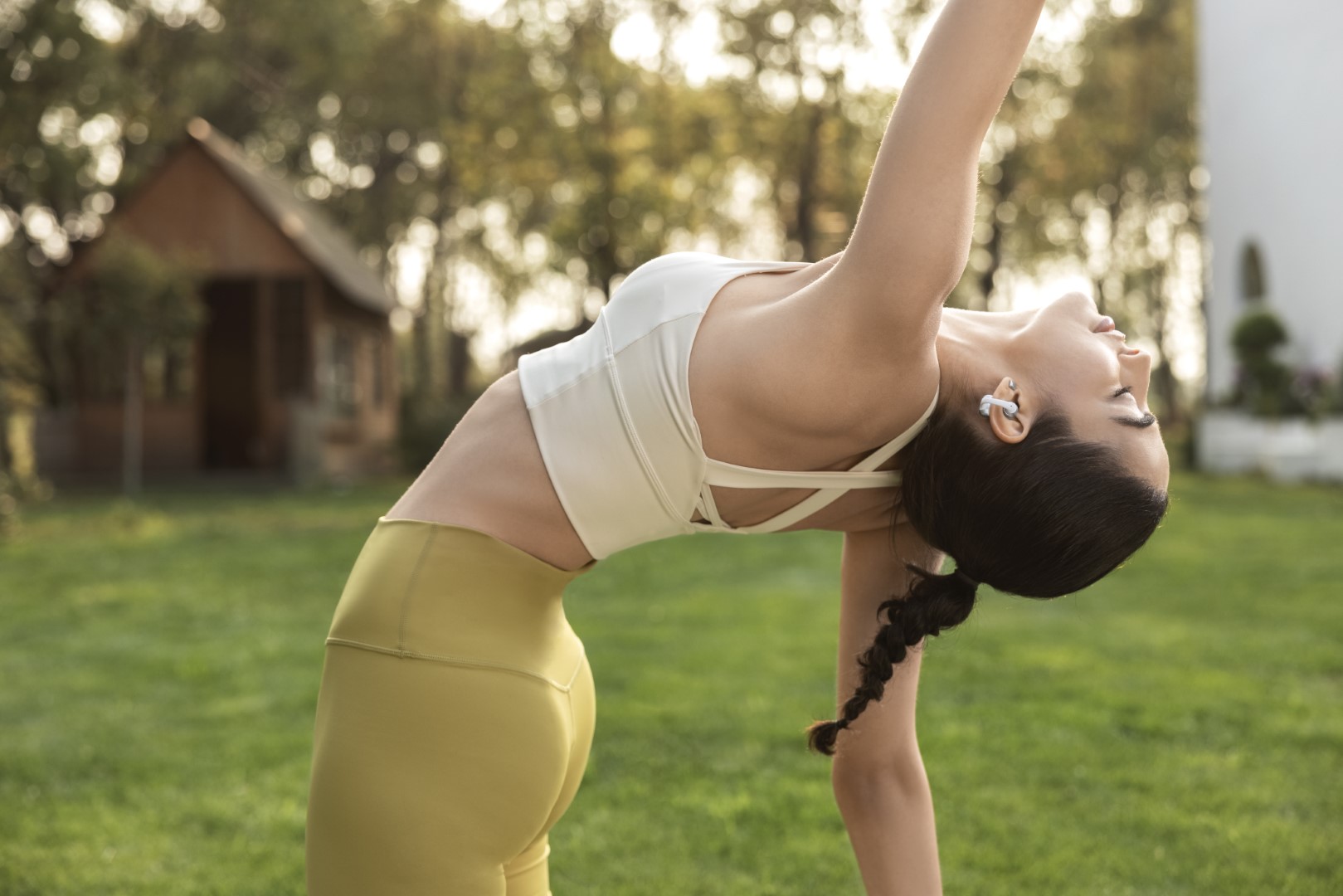 Shokz OpenDots 2 a OpenDots Air: Otvorené slúchadlá, ktoré vás neodstrihnú od okolia Žena cvičí jogu s otvorenými slúchadlami Shokz OpenDots 2