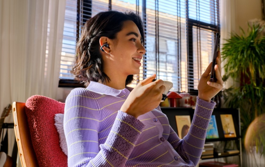 Shokz OpenDots 2 a OpenDots Air: Otvorené slúchadlá, ktoré vás neodstrihnú od okolia Žena má slúchadlá OpenDots Air a sleduje video na svojom mobilnom telefóne