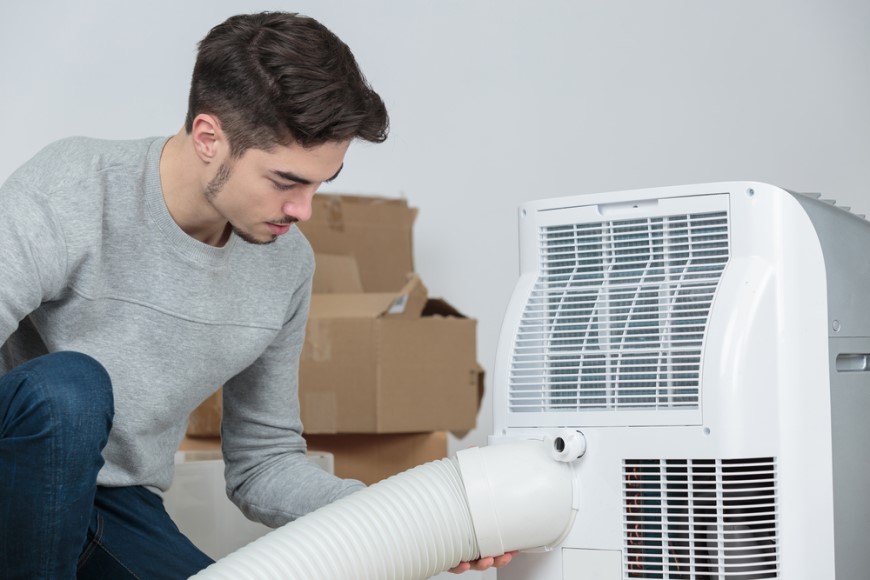 Ako vybrať klimatizáciu? Nemýľte si ju s ochladzovačom muž zapája hadicu pre odvod vzduchu do mobilnej klimatizácie
