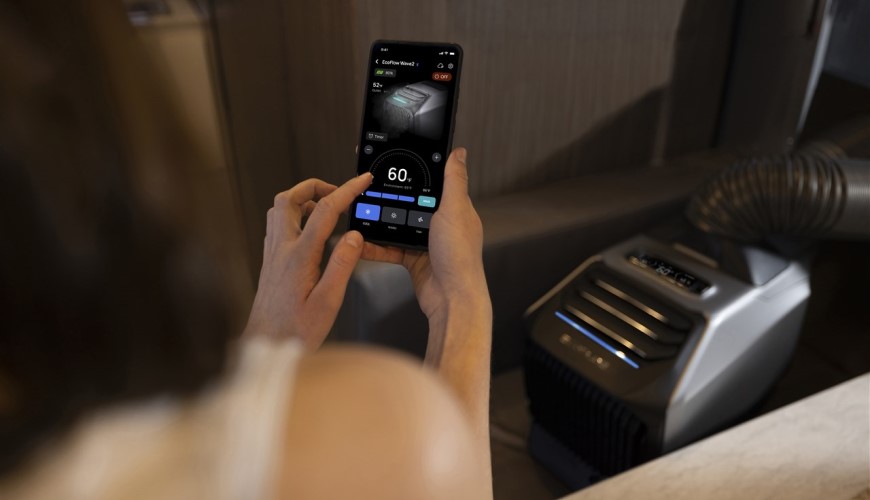 Ako vybrať klimatizáciu? Nemýľte si ju s ochladzovačom žena nastavuje mobilnú klimatizáciu, ktorú má pred sebou, cez aplikáciu v mobile