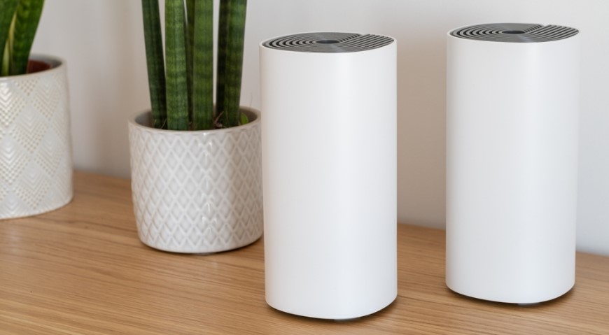 Ako vybrať router? Biele wi-fi router položený na poličke.