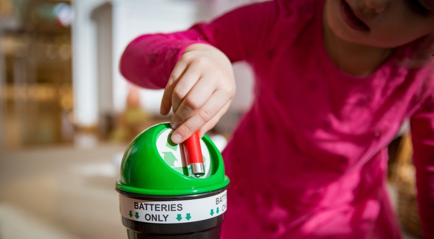Ako vybrať batérie? Dieťa hádže batériu do malého koša na recykláciu
