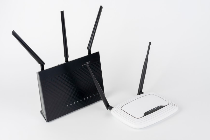 Ako prepojiť dva routery? čierny router s tromi anténami a biely router vedľa seba s bielym pozadím