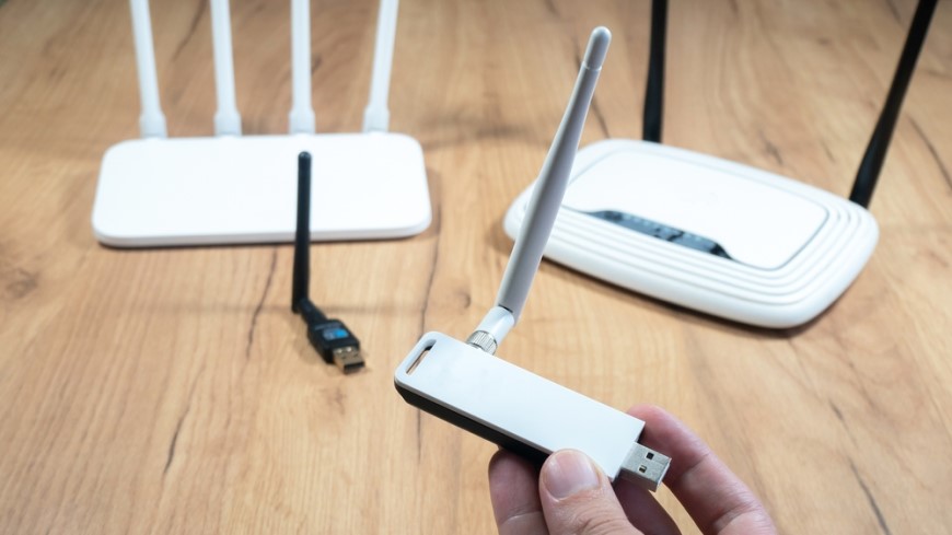 Ako pripojiť TV k Wi-Fi? usb konektor v prstoch a wifi routre na stole