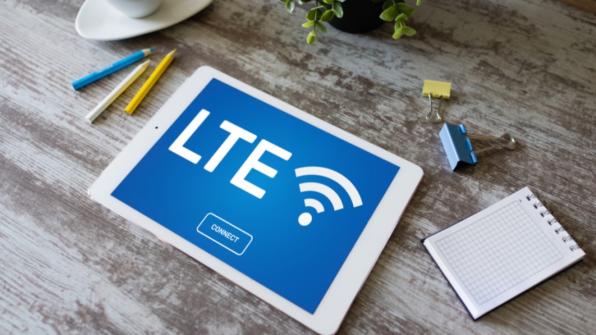 Ako bojovať so zlým signálom televízora? detailný pohľad zhora na tablet, ktorý má na obrazovke symbol LTE a je položený uprostred stola spolu s ceruzkami, poznámkovým blokom a izbovou rastlinou
