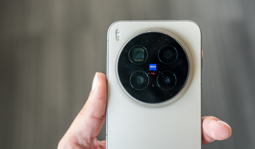 Recenzia: vivo X300 Pro – S kráľom zoomu určite nešliapnete vedľa Pohľad zhora na ruku, ktorá drží smartfón vivo X300 Pro otočený zadnou stranou nahor. Viditeľný je fotomodul telefónu a logo ZEISS uprostred modulu s fotoaparátmi.