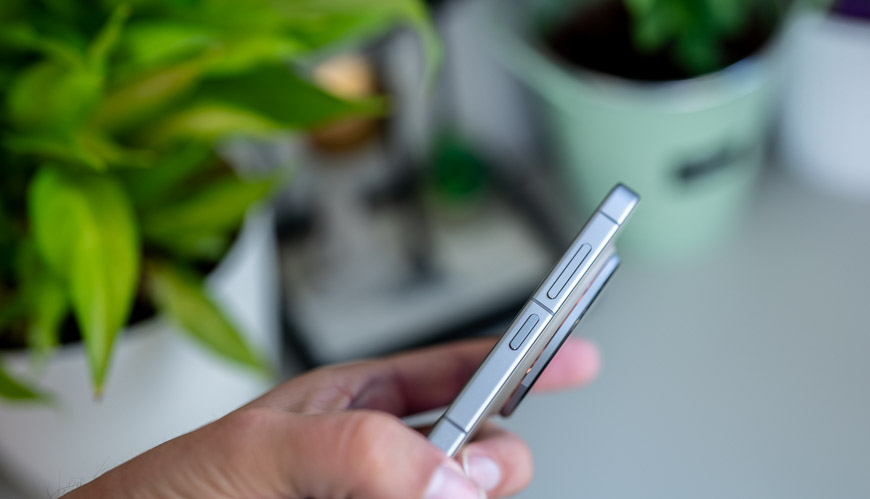 Recenzia: vivo X300 Pro – S kráľom zoomu určite nešliapnete vedľa Pohľad na ruku, ktorá drží smartfón vivo X300 Pro, ktorý vidíme z bočného uhla. V pozadí sú rozostrené izbové kvety.