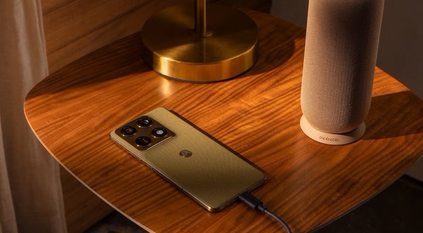 Smartphone Motorola Snapdragon ležiaci na stole a pripojený k nabíjacímu káblu