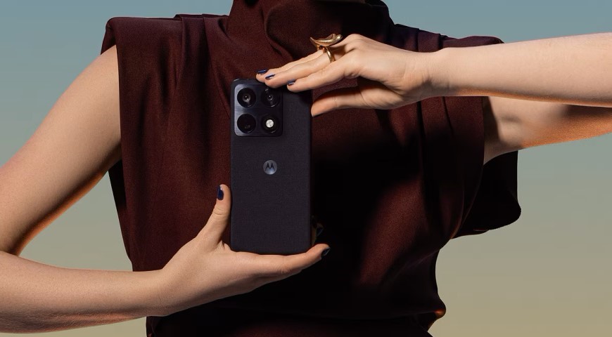 Žena v elegantných topánkach drží mobilný telefón Motorola Signature