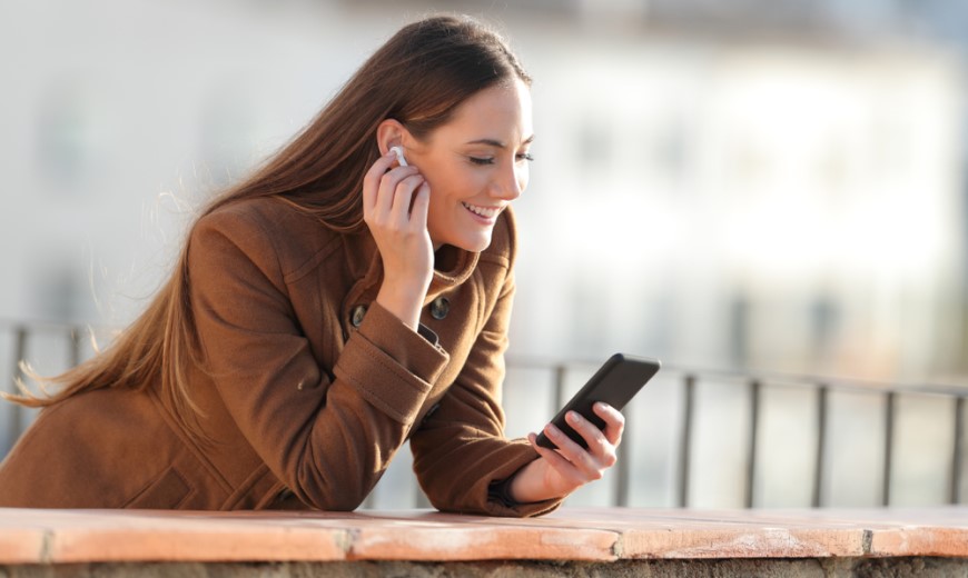 Ako pripojiť bezdrôtové slúchadlá? Žena počúvajúca hudbu cez Bluetooth slúchadlá.
