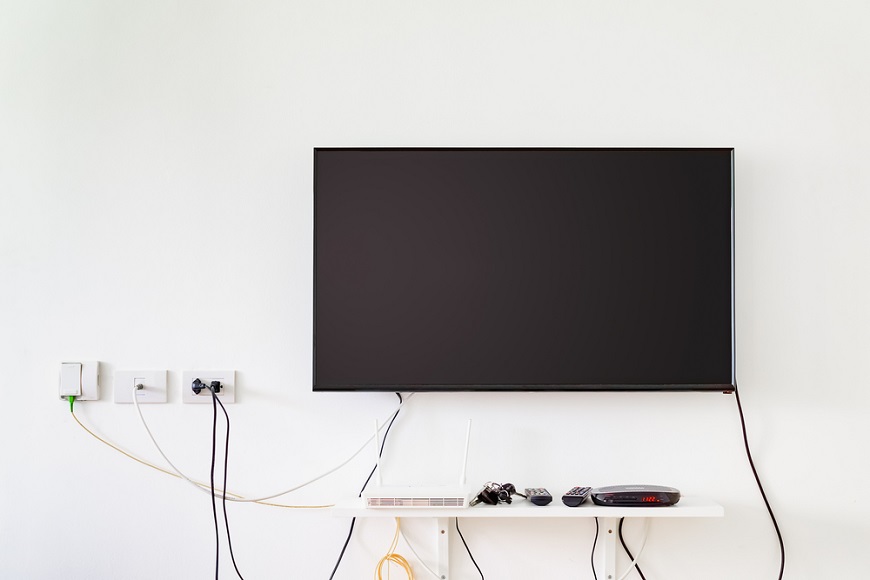 Ako schovať káble od TV? televízor na stene s množstvom káblov