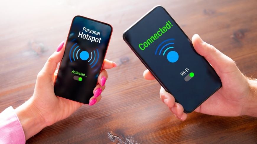 Mobilné telefóny v ruke pripájajúce sa na hotspot.