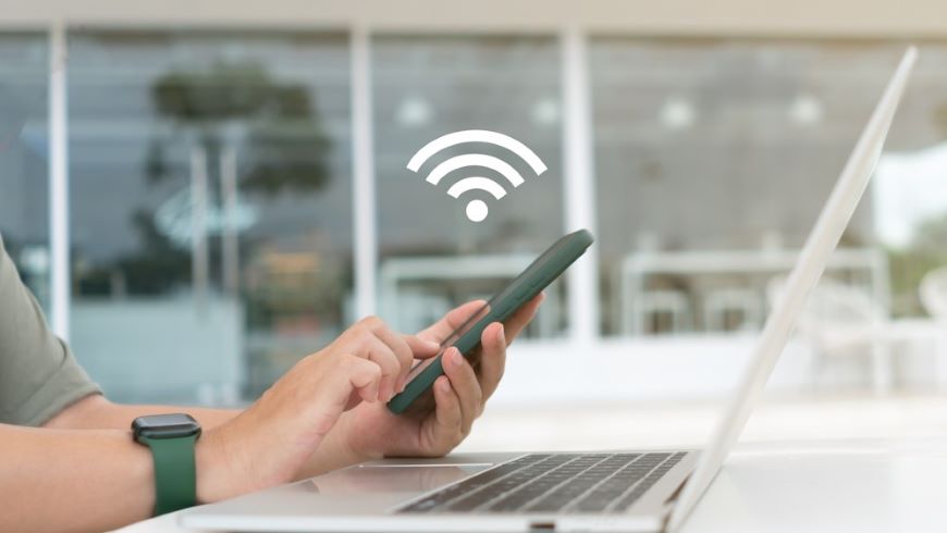 Muž využíva mobilný hotspot na pripojenie počítača k internetu.