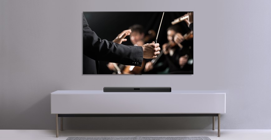 Televízor na stene a pod ním uloženy soundbar.
