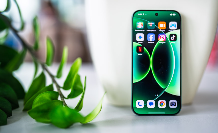 Smartfón Xiaomi 17 stojaci vedľa kvetináča na stole.