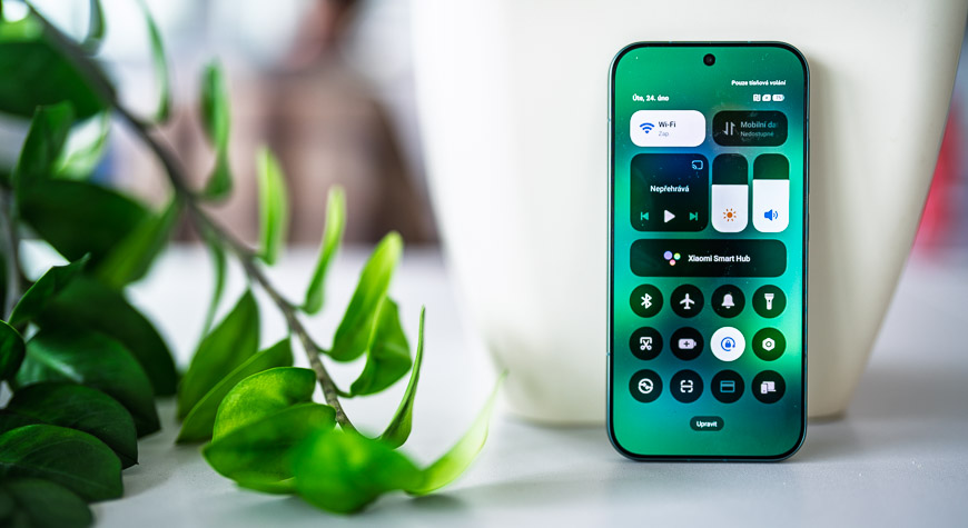 Smartfón Xiaomi 17 opretý o kvetináč s viditeľnými ikonami ovládania na displeji.