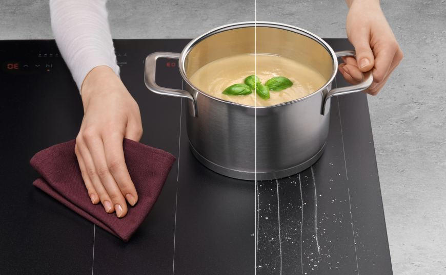 Matné indukčné varné dosky Amica – elegancia, odolnosť a maximálny výkon Hrniec na varnej doske a ruka umývajúca handričkou povrch,