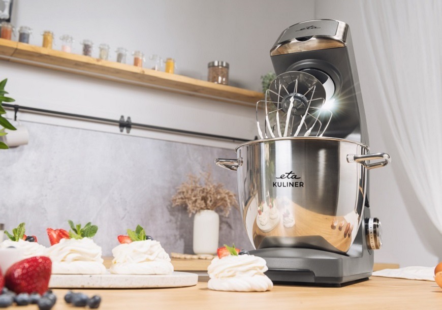 Kuchynský robot ETA Gratus Kuliner II Max: špičkový výkon a neprekonateľné príslušenstvo Detail sivého kuchynského robotu ETA Gratus Kuliner II Max s vyklopeným ramenom a osvetlením misy pri šľahaní bielkového krému na dezerty