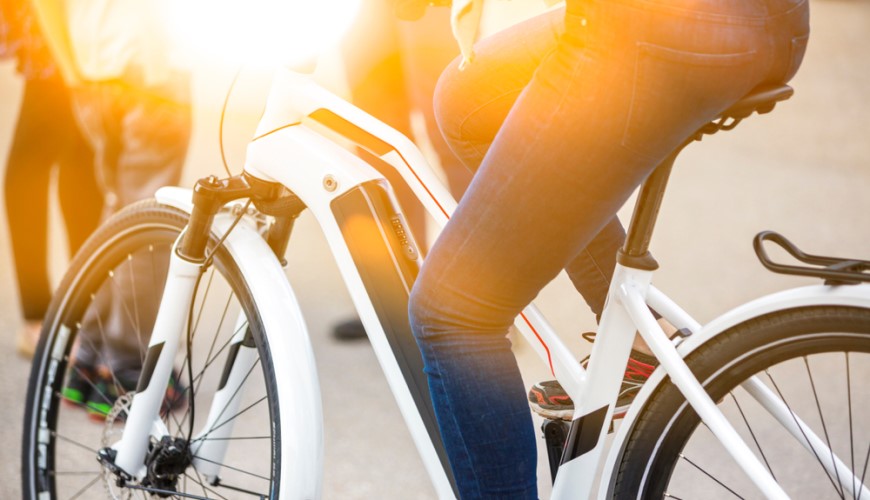 Ako vybrať elektrobicykel? detail ženy na dámskom bicykli, záber na kolesá a nohy