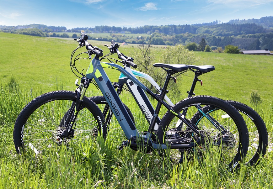 TOP dôvody, prečo si kúpiť elektrobicykel v NAY Dva elektrobicykle stojace na lúke.