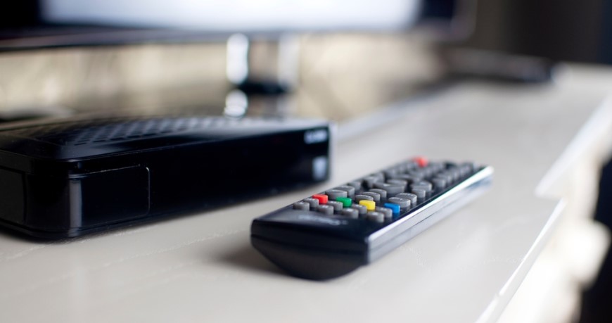 Ako vybrať a zapojiť set-top box? Diaľkové ovládanie položené pri televízore.