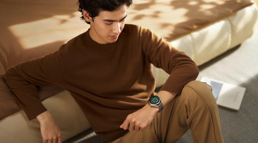 Huawei Watch Buds 2: Keď hodinky ukrývajú slúchadlá Muž sedici vedľa postele sleduje svoje Huawei Watch Buds 2.