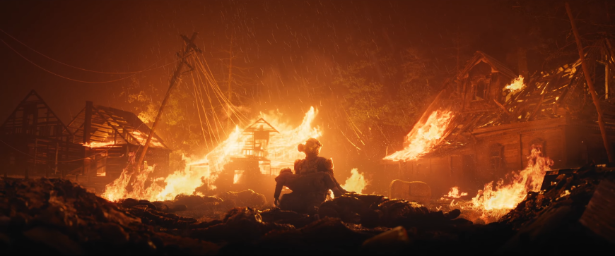 Nové Metro 2039 prichádza: Hor sa do podzemia! (aktualizované) Postava Cudzinca drží v náručí dieťa na pozadí horiacich trosiek, screenshot z traileru