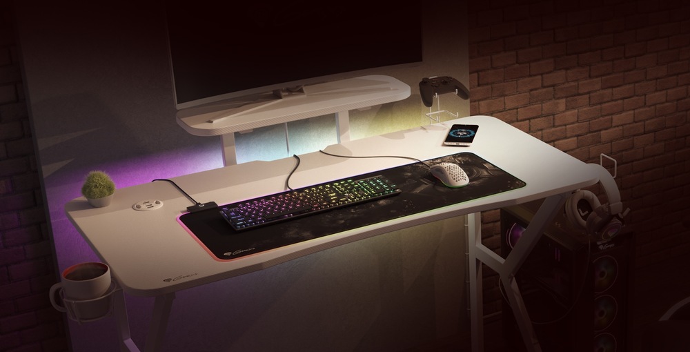 Ako vybrať herný stôl? Na herním stole stojí monitor na polici, na desce stolu je položena klávesnice a myš na podložce, stůl má RGB podsvícení