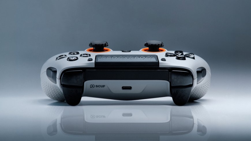 Herný ovládač Scuf Omega pre PS5 v bielom vyhotovení s oranžovými detailmi leží na stole