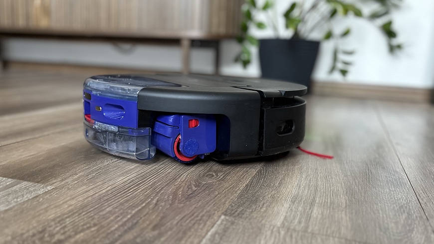  Robotický vysávač Dyson Spot+Scrub AI upratuje v obývacej izbe.