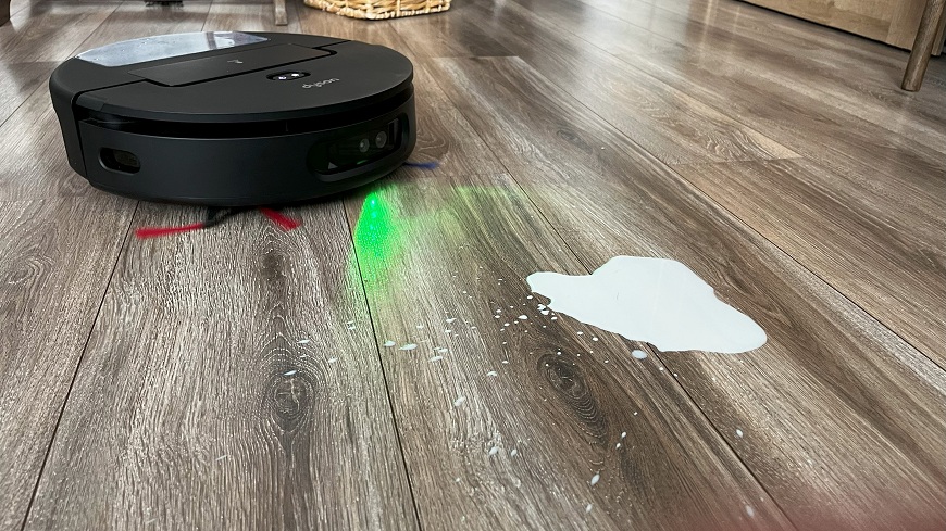  Robotický vysávač Dyson Spot+Scrub AI ide vyčistiť podlahu s rozliatym mliekom.