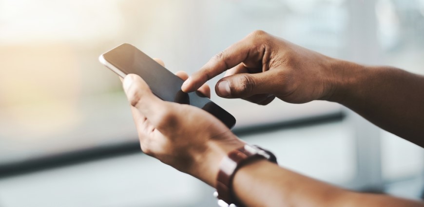 Ako aktualizovať Android: Kompletný sprievodca a užitočné rady Mužské ruky držia mobilný telefón. Pravá ruka sa ukazovákom dotýka displeja.