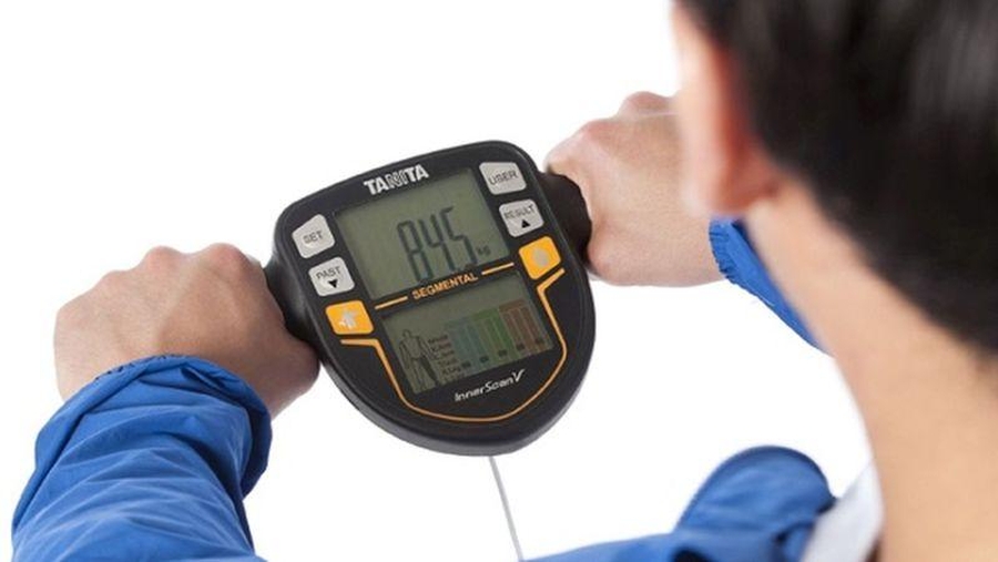 Ako vybrať osobnú váhu? Muž sa váži na diagnostickej digitálnej váhe Tanita BC 545N.