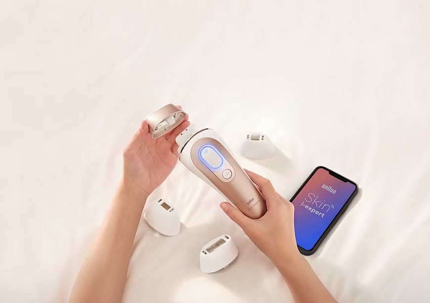 Ako správne používať IPL epilátor Braun a dosiahnuť dlhodobo hladkú pokožku? Žena drží epilátor v rukách a nasadzuje nadstavec.