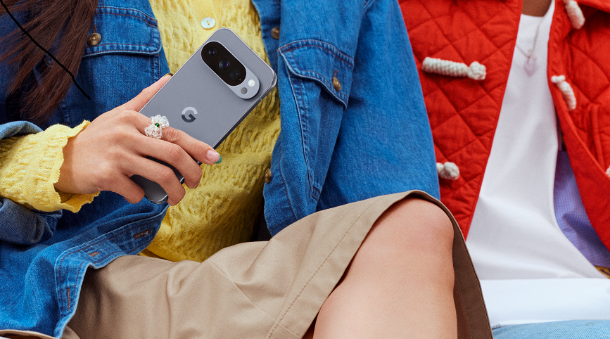 žena sedí vedľa muža drží v ruke smartfón Google Pixel 10, detail 