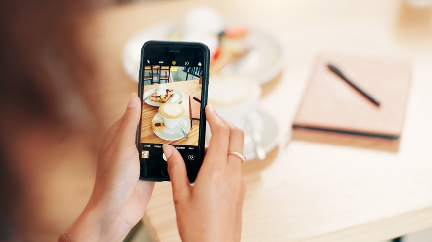  Žena surfujúca vo fotoaplikácii mobilného telefónu v snahe zaobstarať perfektnú snímku jedla