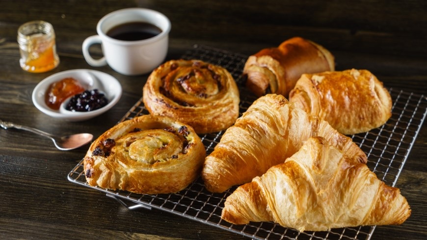 Čo (ne)patrí do chladničky? croissanty a slimáky z lístkového cesta na podnose vedľa džemu a kávy