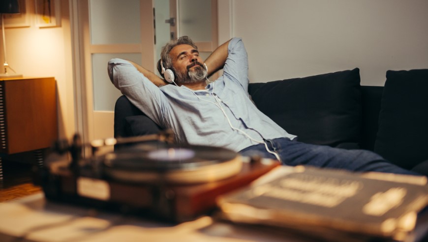 muž so slúchadlami na hlave počúva vinylovú dosku