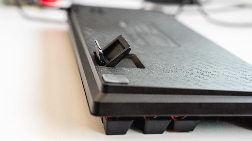 Herná klávesnica Razer Huntsman Tenkeyless V3 8KHz leží otočená hore nohami, nastaviteľné dvojité nožičky sú napoly vytiahnuté
