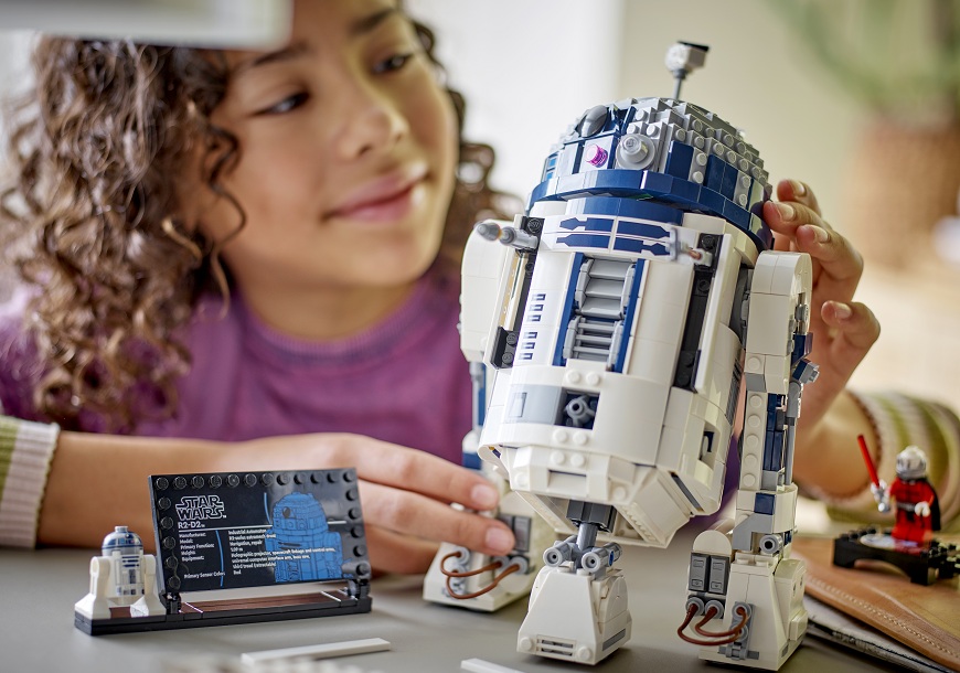Stavebnica LEGO® prichádza do NAY: Od prvých kociek až po monumentálne sety pre dospelých Dievča skladá stavebnicu LEGO Star Wars R2 D2.