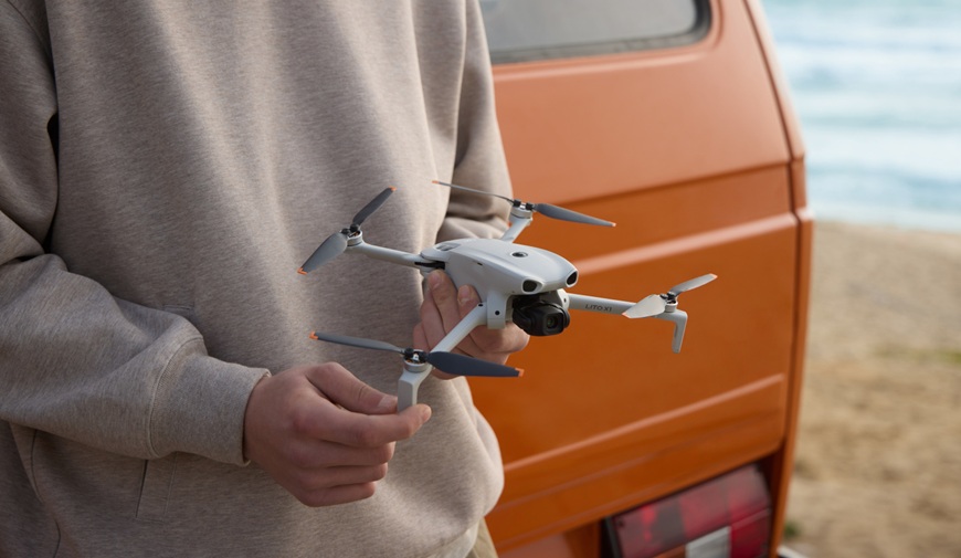 Aký DJI dron vybrať? Porovnanie modelov pre začiatočníkov, cestovanie aj profesionálnu tvorbu muž drží dron dji liato x1 pred dodávkou