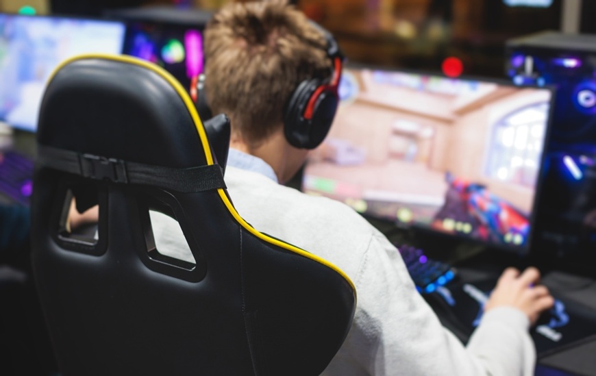 Jeseň v pohybe: So slúchadlami ide všetko lepšie pohľad na muža zozadu hrajúceho hru na pc