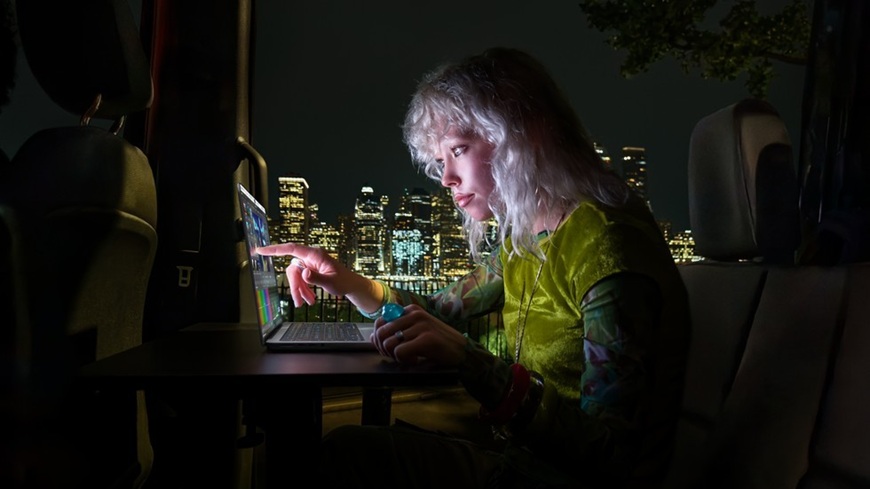 Láska na prvý PROLED! Apple do tretice všetkého nového predstavil prvý dotykový MacBook Pro Mladá blonďavá žena dotýkajúca sa prstom PROLED displeja MacBooku Pro