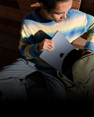 Niekto vkladá 15-palcový MacBook Air v polnočnej farbe do batoha